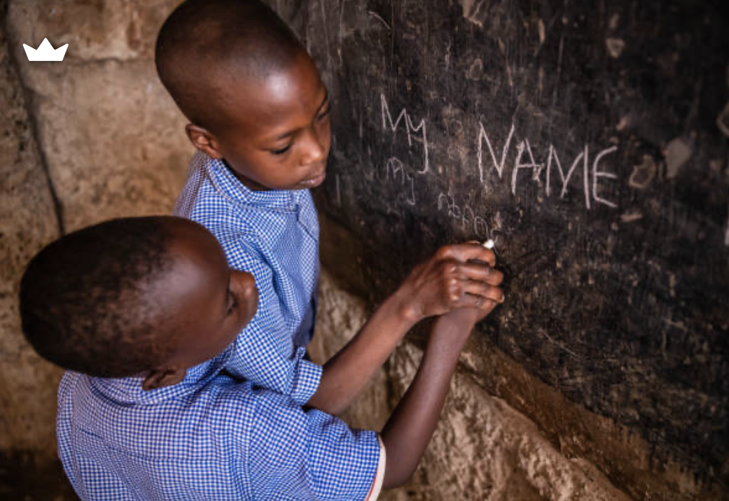 Lower Primary pupils practising letters on a chalkboard