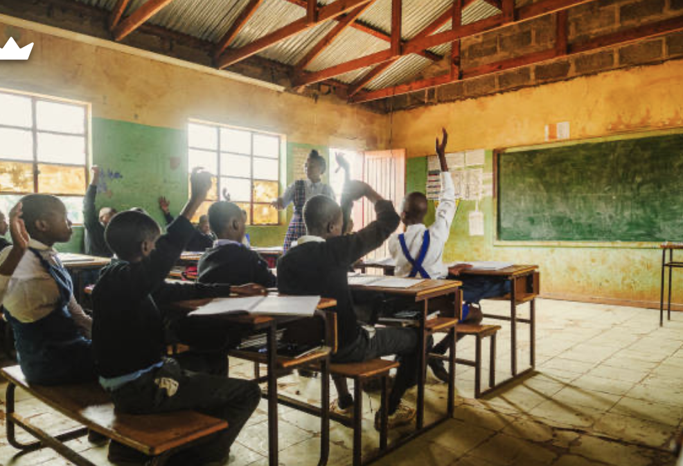A teacher assisting pupils at their desks
