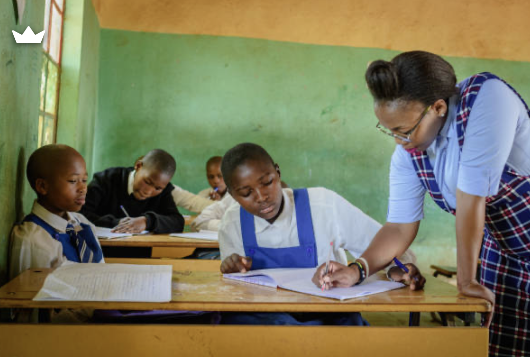 A teacher helping a pupil with her exercise book